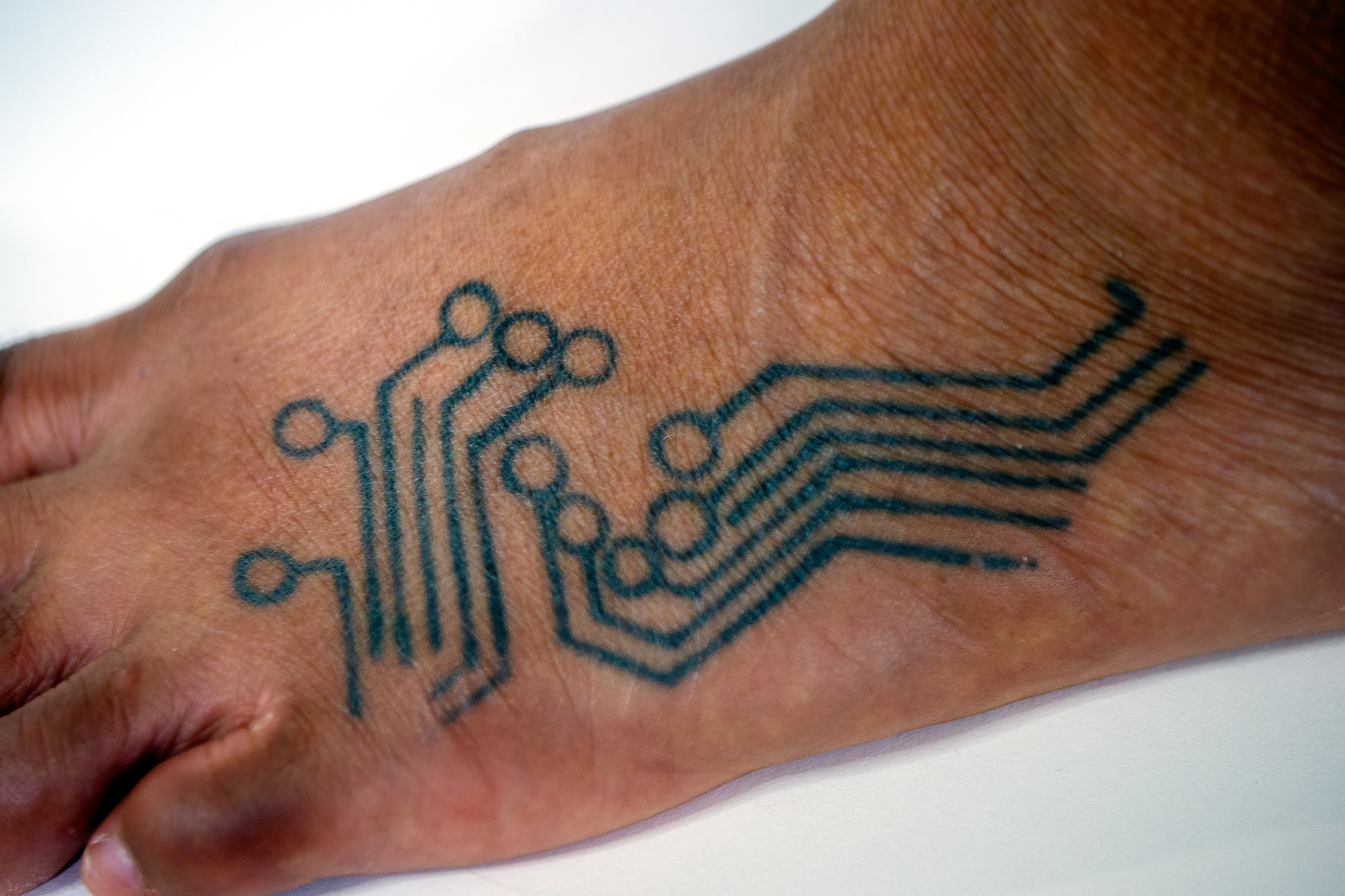A foot tattoo of circuitry.