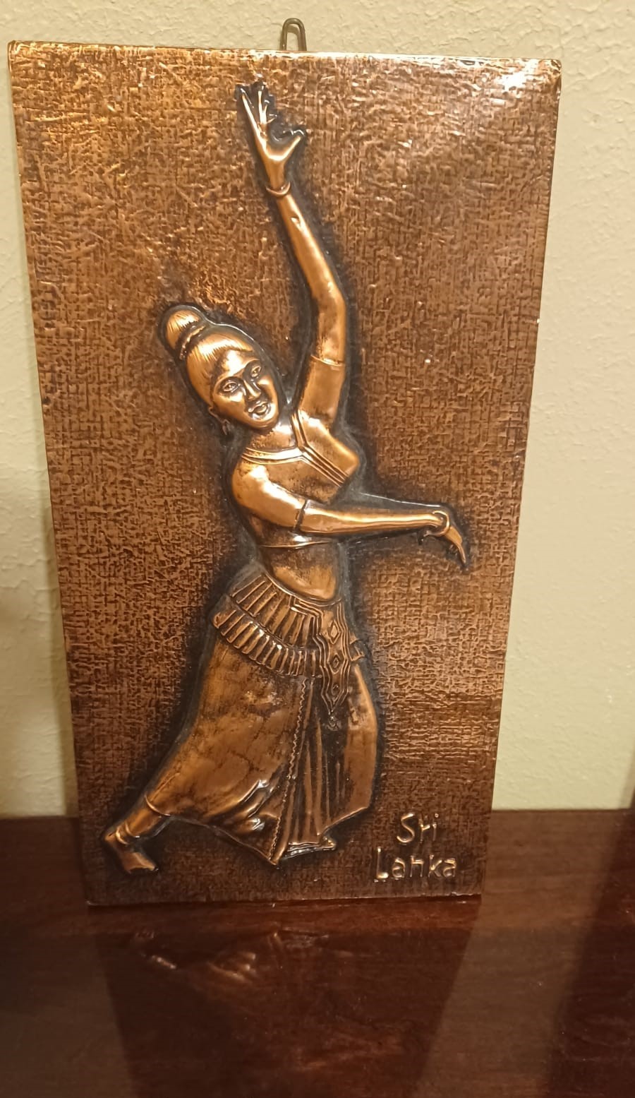 A brass plaque depicts a woman dancer wearing anklets, bangles, and an ornamented chignon in relief, with 'Sri Lanka' embossed in the lower right.