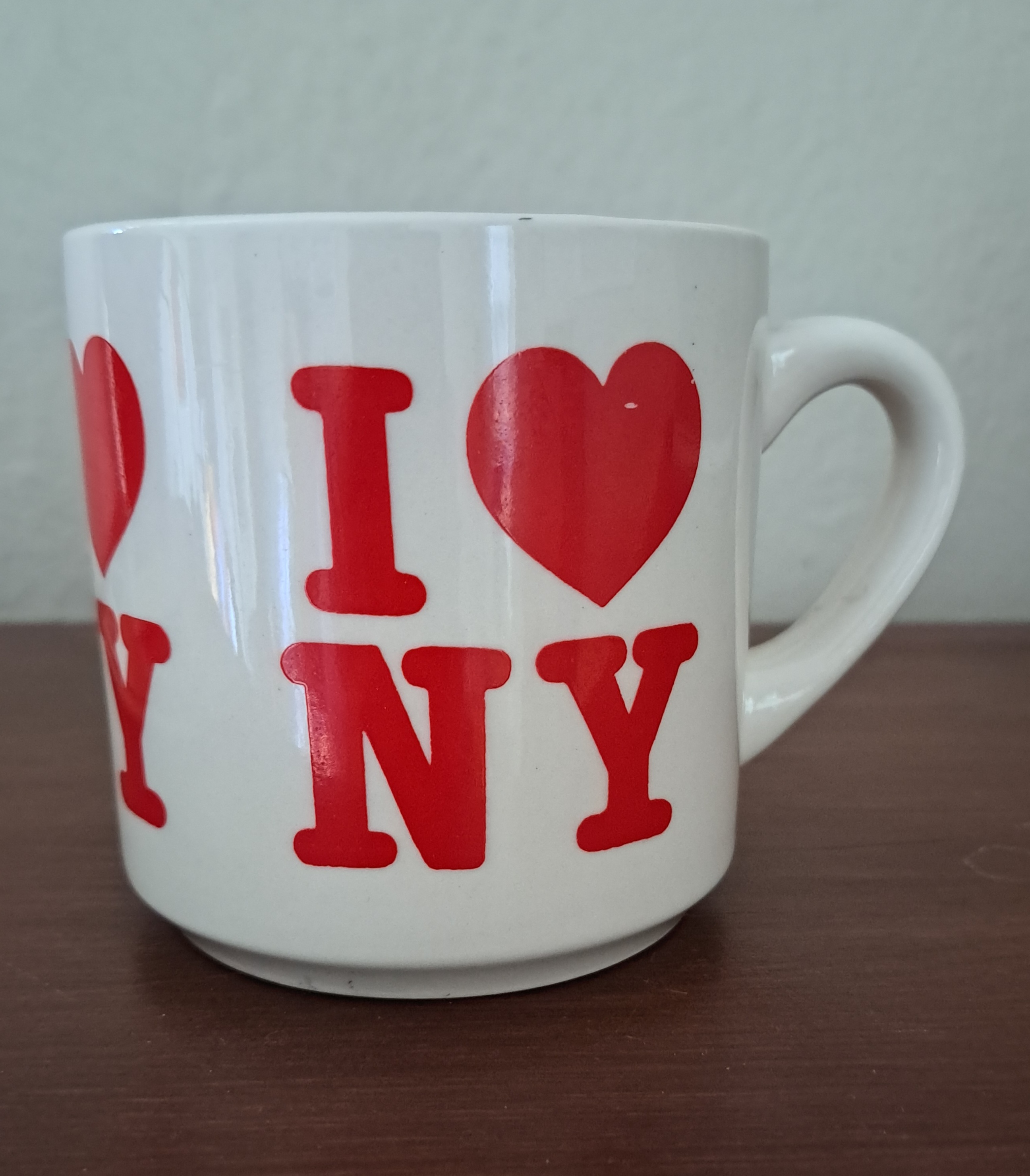 A tourist mug, yellowed with age, reads 'I Heart NY' in red bold lettering.