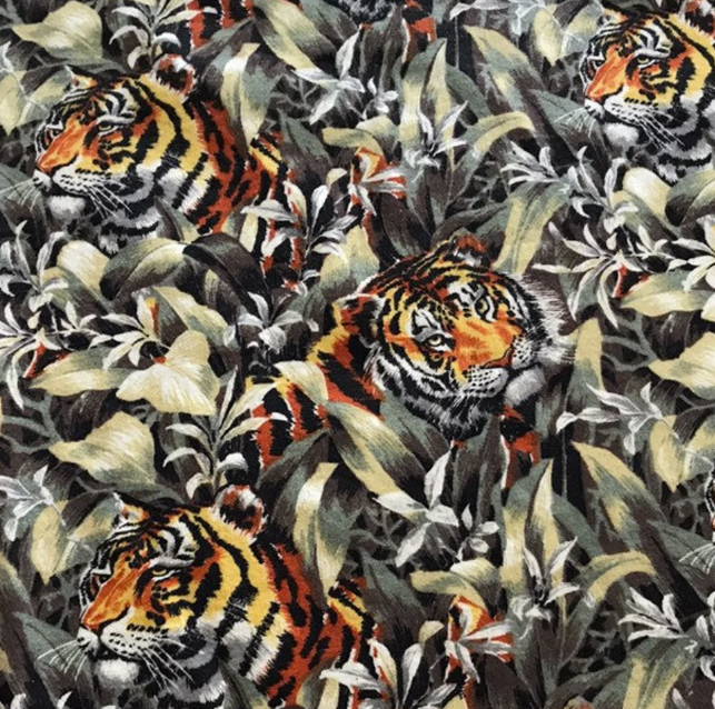 A bedspread depicts tigers peering through dense jungle foliage.